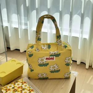 Detailed macro view of yellow floral daisy mother-and-baby tote bag with mimi logo patch