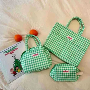 Detailed view of the green gingham multi-functional bag set with mimi label.