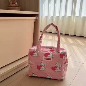 Cute pink tote bag featuring rabbit heart patterns displayed in a cozy home interior