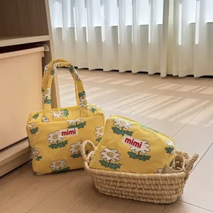 Charming yellow daisy print tote and cosmetic bag set displayed in a home nursery.