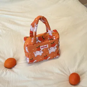 Detailed view of the cute orange pattern and 'mimi' label on the toddler tote bag.