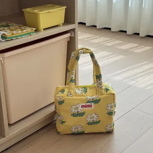 Detailed view of a yellow daisy print mommy bag featuring a spacious storage design.