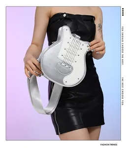 Unique silver and white guitar shaped crossbody bag with rivets held by fashion model