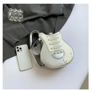 Creative guitar shaped silver and white crossbody bag with studs shown for scale