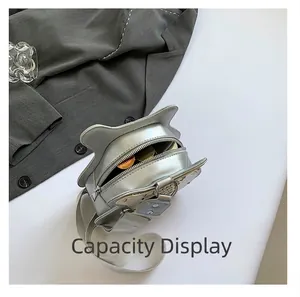 Detail view of the silver guitar-shaped crossbody bag showing internal capacity
