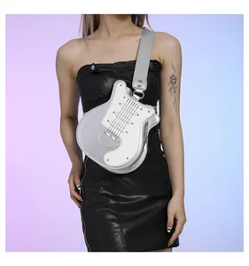 Close-up of a stylish silver guitar-shaped crossbody bag with rivet details worn by model