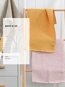 Detail shot of honeycomb waffle texture on soft pure cotton towels in pastel colors