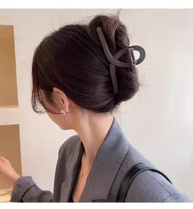 Close-up of a matte large hair claw clip on an elegant bun hairstyle for thick hair.
