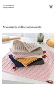 Detail view of stacked colorful waffle weave cotton face towels in a home setting
