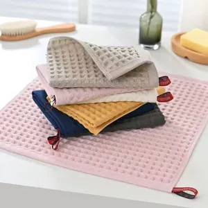Set of soft waffle weave cotton towels with absorbent honeycomb texture in various colors.