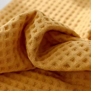 Close-up of a soft yellow waffle weave pure cotton towel with honeycomb texture