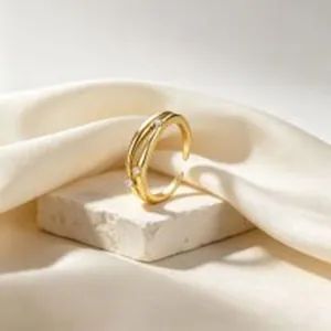 Detailansicht eines vergoldeten verstellbaren Rings mit Kristallen auf strukturiertem Stein.