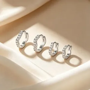 Nahaufnahme von vier 925er Sterling Silber Creolen mit funkelnden Zirkonia auf Seide