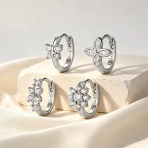 Makro-Detail von vier S925 Sterling Silber Creolen mit funkelnden Kristallanhängern