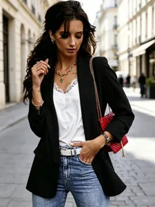 Elegante blazer nero sciancrato da donna, abbinato a un top in pizzo per un look da ufficio.