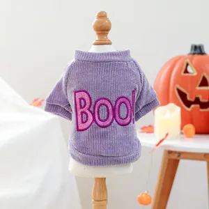 Detail showing pink glittery BOO! embroidery on a purple corduroy Halloween pet sweater