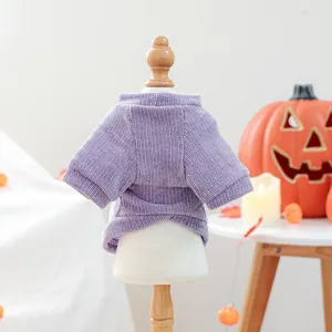 Detail view of a purple corduroy pet sweater with warm Halloween festive decor.