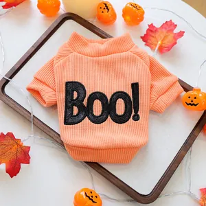 Detailed view of the knit texture and festive embroidered 'Boo!' text on an orange pet sweater.