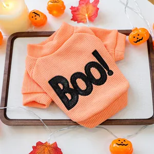 Close-up of orange Halloween pet sweater with "BOO!" glitter embroidery detail.