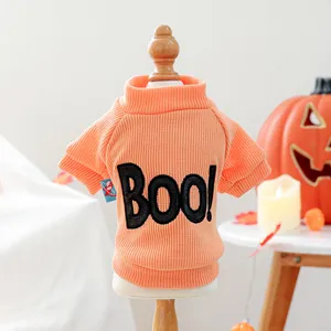 Close-up of orange Halloween pet sweater with BOO text on a small wooden mannequin