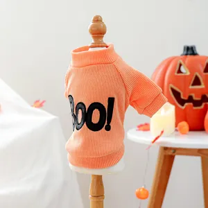 Close-up detail of knitted orange Halloween pet sweater featuring a bold 'BOO!' print.