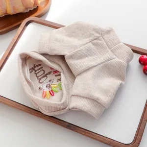 Close-up of beige ribbed knit pet sweater featuring fine colorful embroidery detail.