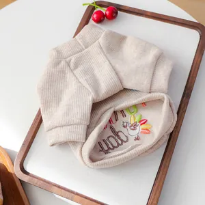 Detail showing soft ribbed knit texture and embroidered turkey design on pet sweater