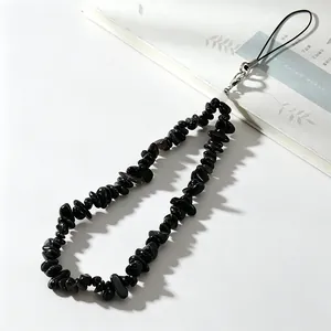 Close-up detail of natural black obsidian stone beaded phone lanyard wrist strap.
