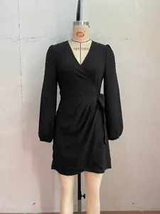 Elegant long sleeve black wrap mini dress with V-neck and subtle polka dot texture detail