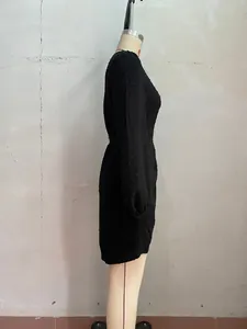 Side view detail showing the texture of a black Swiss dot long sleeve mini dress