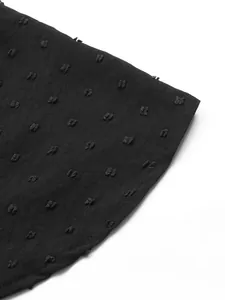 Detailed macro view showing the textured black Swiss dot fabric of this elegant dress