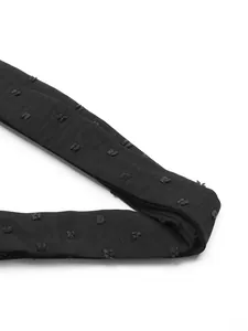 Close-up of black fabric with raised dot texture for elegant long sleeve V-neck dress