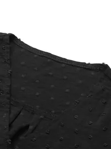 Close-up view of the V-neckline and Swiss dot texture on a black long-sleeved dress.