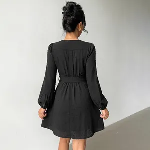 Elegant black long-sleeved V-neck mini dress with Swiss dot texture and belt