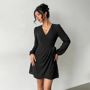 Elegant black V-neck long sleeve wrap dress with Swiss dot texture and tie waist detail.