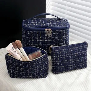 Three-piece navy blue tweed cosmetic bag set with elegant gold threading