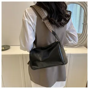 Detailed view of casual black pillow bag with wide patterned shoulder strap