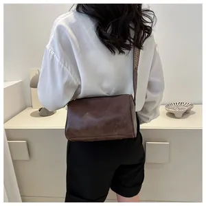 Detailed rear view of a brown casual pillow bag with a wide strap worn by a woman