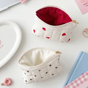 Two quilted white pouches with heart patterns for cosmetics, jewelry and coins storage