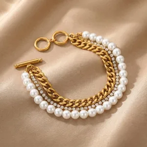 Detailed view of the gold multi-layer bracelet with zirconia chain and shell pearls