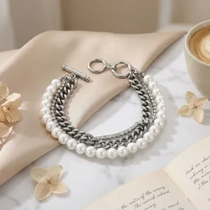Close-up of a multi-layered stainless steel bracelet with white shell pearls and crystals