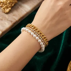 Detail shot of a multi-layer gold chain bracelet with zirconia and white shell pearls.