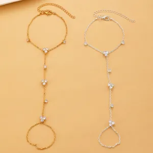 Dainty gold and silver crystal finger bracelets featuring flower patterns on hand back.