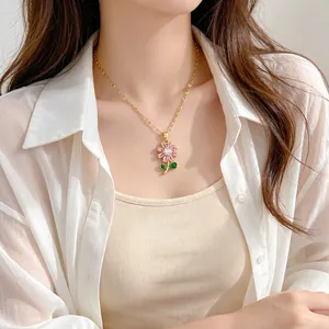 Gros plan d'un élégant collier doré avec un pendentif en fleur de zircone rose