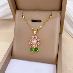 Détail du collier en acier titane avec pendentif fleur serti de zircons roses et verts