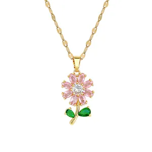 Vue macro détaillée d'un pendentif fleur plaqué or avec zircons roses et verts