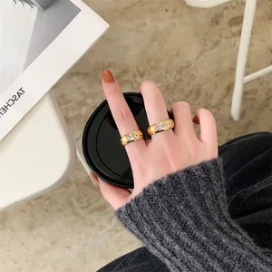 Close-up detail of vintage titanium steel rings with square and marquise stones on a hand.