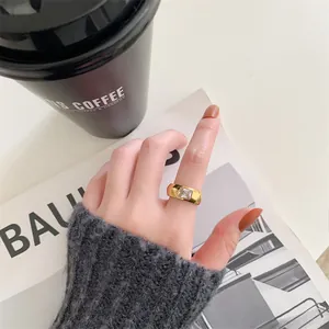 Close-up of a vintage gold stainless steel ring featuring a square crystal on finger.
