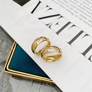 Close-up of gold-plated titanium steel rings with marquise and square zirconia stones