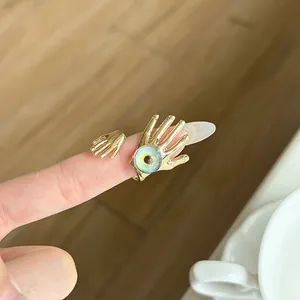 Detailed view of a vintage gold-toned evil eye ring featuring a unique hand-shaped design